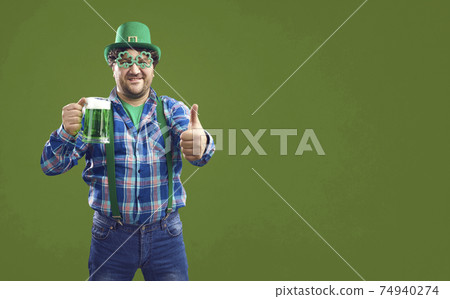 Happy Irish man holding a glass and giving a thumbs recommending good quality beer Happy Irish man holding a glass and giving a thumbs recommending good quality beer 74940274