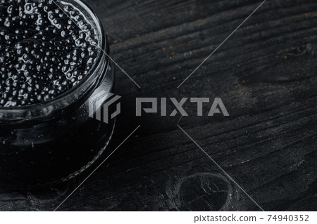 Jar of black caviar, on black wooden table background with copy space for text Jar of black caviar, on black wooden table background with copy space for text 74940352