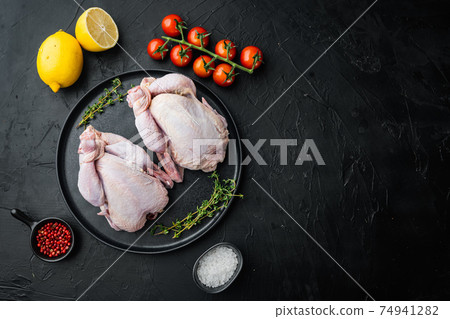 Fresh whole poult with herbs spices ingredients, on black background, top view with copy space for text Fresh whole poult with herbs spices ingredients, on black background, top view with copy space for text 74941282