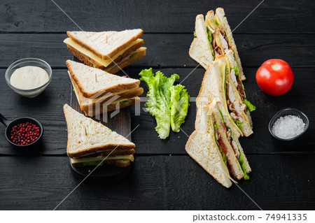 Deli meat sandwich with chicken, on black wooden table Deli meat sandwich with chicken, on black wooden table 74941335