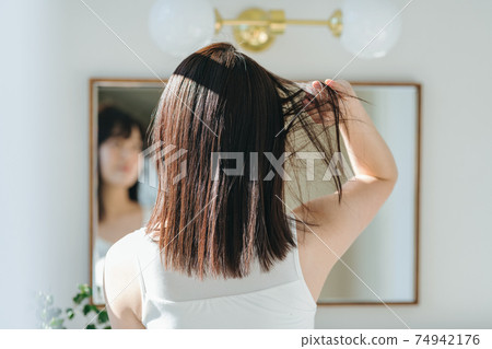 一個女人，她的頭髮在鏡子前飄揚 74942176