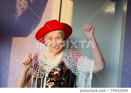 Happy smiling funny senior woman wearing beads dancing 74942604