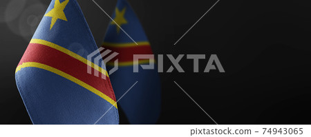 Small national flags of the Democratic Republic of the Congo on a dark background 74943065