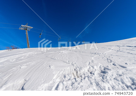 Empty Chairlift in Snowy Winter Landscape - Malga San Giorgio Ski Resort Italy Empty Chairlift in Snowy Winter Landscape - Malga San Giorgio Ski Resort Italy 74943720