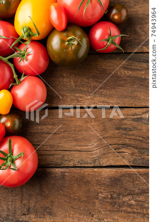 Overhead shot of red, yellow and green tomatoes on rustic table with copyspace. Food background. Top view 74943964