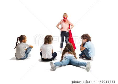 Child pretending to be a superhero with her friends sitting around Child pretending to be a superhero with her friends sitting around 74944113