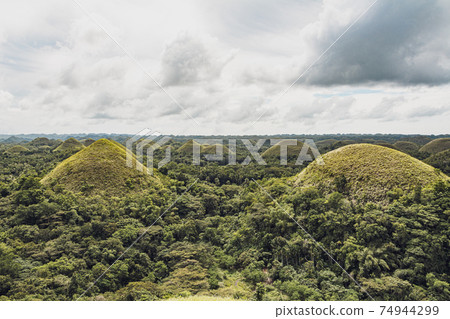 Chocolate Hills with a group of clouds in the sky 74944299