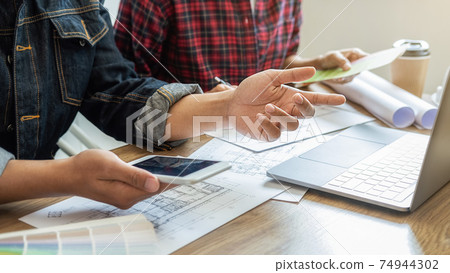 Interior designer and Architect choosing color in color swatch samples chart for house coloring selection in office with blueprint. Construction concept. Interior designer and Architect choosing color in color swatch samples chart for house coloring selection in office with blueprint. Construction concept. 74944302