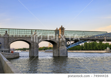 A large glass bridge over the river on thick columns. A large glass bridge over the river on thick columns. 74944416