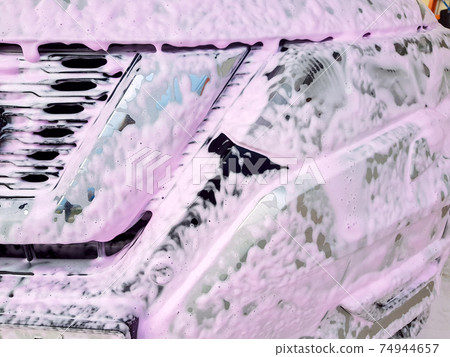dirty car radiator grille and headlight covered with foam for washing and cleaning from dirt and insects, nobody closeup details. dirty car radiator grille and headlight covered with foam for washing and cleaning from dirt and insects, nobody closeup details. 74944657
