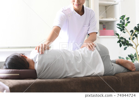 一名女子在整脊骨盆矯正期間接受按摩 一名女子在整脊骨盆矯正期間接受按摩 74944724