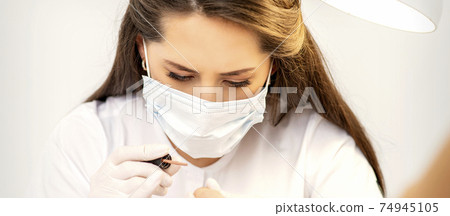 Manicure master is painting nails 74945105