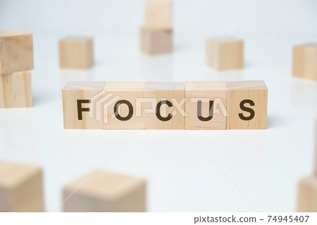 Modern business buzzword - focus. Word on wooden blocks on a white background. Modern business buzzword - focus. Word on wooden blocks on a white background. 74945407