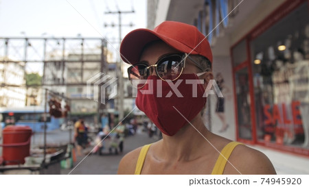 Woman travel caucasian visitor at a supermarket with wearing protective medical mask. Girl tourist customer a grocery store with protect respirator. Woman travel caucasian visitor at a supermarket with wearing protective medical mask. Girl tourist customer a grocery store with protect respirator. 74945920