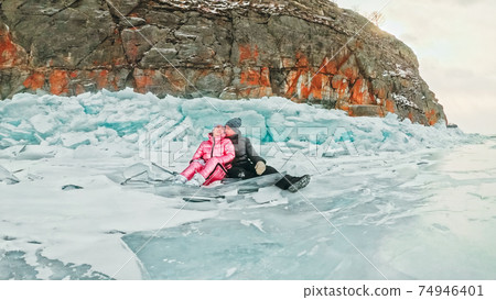 Couple has fun during winter walk against background of ice of f Couple has fun during winter walk against background of ice of f 74946401