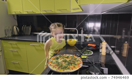 Smart girl learning to cook. Young mistress children to cook a Neapolitan egg fried omelette from salame affumicato sausage. 74946469