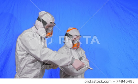 Scientist virologist in respirator makes write in an tablet computer with stylus. Man and woman wearing protective medical mask. Chroma key blue. 74946493