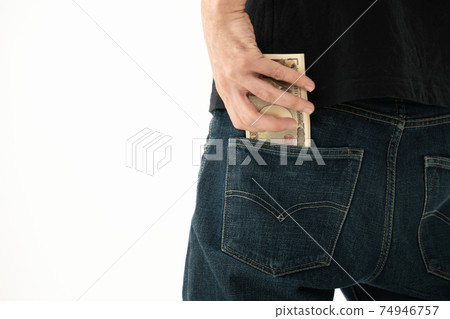 A man who puts money in his pocket, back view A man who puts money in his pocket, back view 74946757