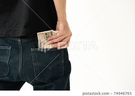 A man who puts money in his pocket, back view A man who puts money in his pocket, back view 74946765