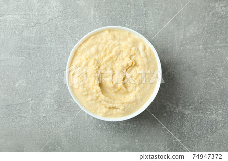 Bowl of fresh hummus on gray background 74947372