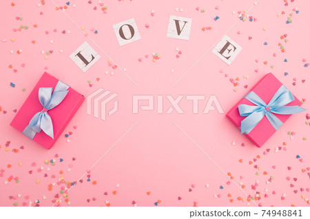 Composition with love inscription and gifts on pink background. Flat lay, top view. 74948841