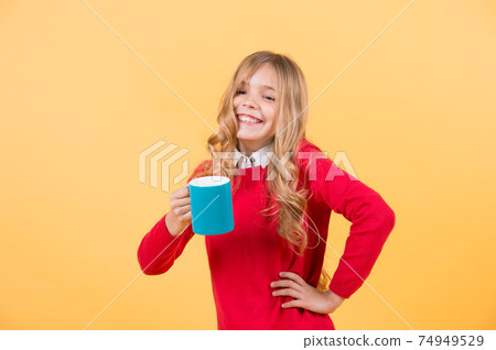 Girl with long blond hair in red sweater hold mug Girl with long blond hair in red sweater hold mug 74949529