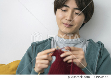 Image of a young man knitting a knitting boy Image of a young man knitting a knitting boy 74950446
