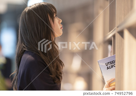 A woman looking for a book 74952796