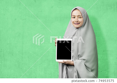 Asian Muslim woman in veil showing blank tablet screen 74953575