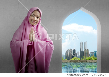 Asian Muslim woman in veil with greeting gesture 74953576