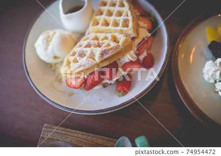 waffle pancake desert with vanilla ice cream, fresh strawberry and honey syrup waffle pancake desert with vanilla ice cream, fresh strawberry and honey syrup 74954472
