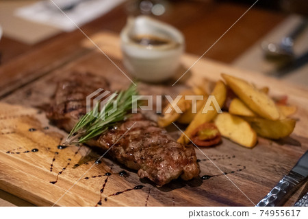 Medium rare meat on plate with sauce and fries Medium rare meat on plate with sauce and fries 74955617