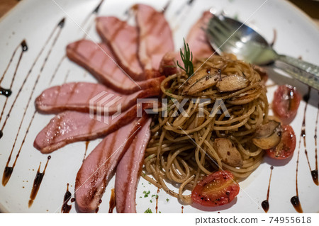 Smoked duck spaghetti served on plate. Smoked duck spaghetti served on plate. 74955618