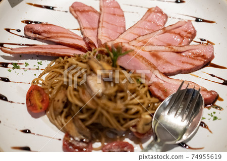 Smoked duck spaghetti served on plate. Smoked duck spaghetti served on plate. 74955619
