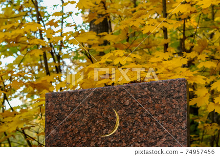 White crescent moon symbol on the grave rectangular granite slab. Muslim background 74957456
