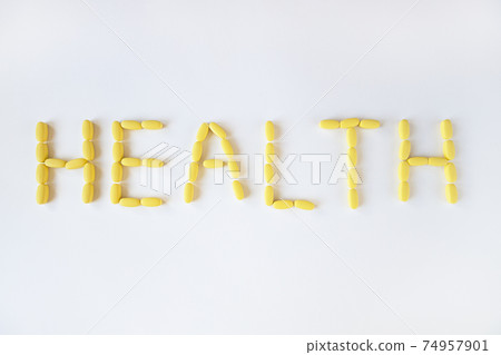 Inscription HEALTH from yellow long pills on white background, macro, close-up, copy space. Nutritional supplements concept, health, vitamins, trendy color of 2021, Illuminating. Horizontal Inscription HEALTH from yellow long pills on white background, macro, close-up, copy space. Nutritional supplements concept, health, vitamins, trendy color of 2021, Illuminating. Horizontal 74957901