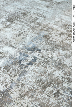 Background from a stylish carpet in neutral gray-beige-blue tones with fading and artificial antiquity effect. Concept details of a fashionable interior, carpets. Abstract texture. Vertical Background from a stylish carpet in neutral gray-beige-blue tones with fading and artificial antiquity effect. Concept details of a fashionable interior, carpets. Abstract texture. Vertical 74957903