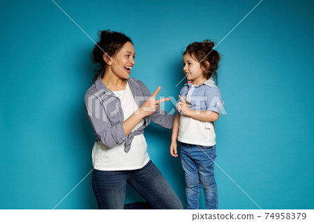 Mother and daughter playing a rock-paper-scissors game. Motherhood and childhood concept. Mother and daughter playing a rock-paper-scissors game. Motherhood and childhood concept. 74958379