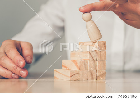 Concept Bankrupt businessman - hand blows abstract figure of a man with a ladder of wooden blocks. Concept Bankrupt businessman - hand blows abstract figure of a man with a ladder of wooden blocks. 74959490