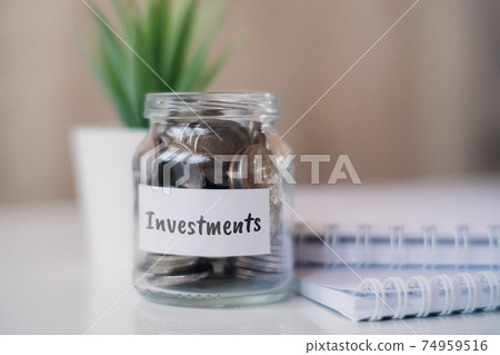 The concept of accumulating money for investments - a glass jar with coins. 74959516
