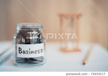 Business money accumulation concept - glass jar with coins. 74959517