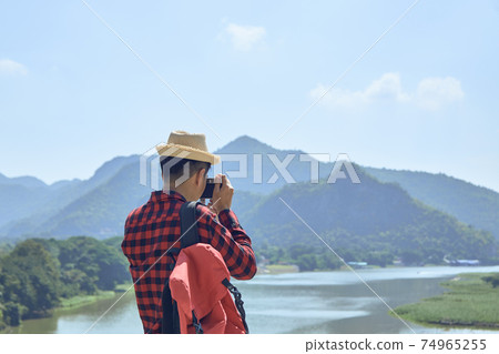 Young man photographing with vintage camera Young man photographing with vintage camera 74965255