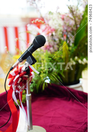 Flowers and microphones on the stage of the ceremony 74968423