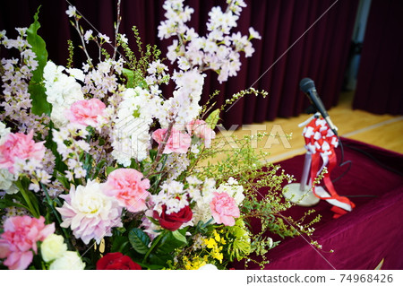 Flowers and microphones on the stage of the ceremony 74968426