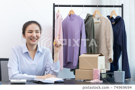 Asian women sell vintage and fashionable clothes through online channels or via social media in her home, Fast and safe delivery by post box, New business during social distances. 74969694