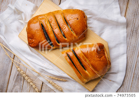 Top view on cut poppy seed bun on the wooden board Top view on cut poppy seed bun on the wooden board 74973505