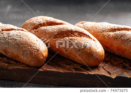 Three loafs of fresh baguette on gray background 74973875