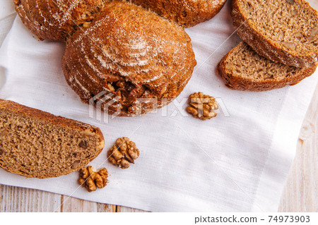 Top view on rye walnut bread on the wooden table 74973903