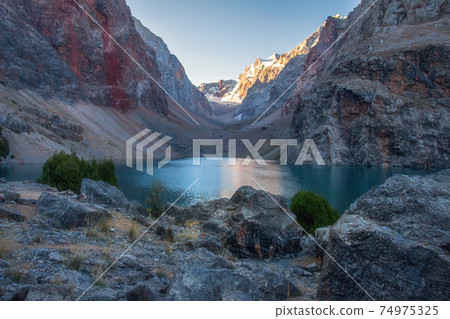 Mountain landscape with lake in the early morning. Tajikistan Fann mountains. View on Greater Allo lake in Asia. Amazing nature mountains landscape. 74975325
