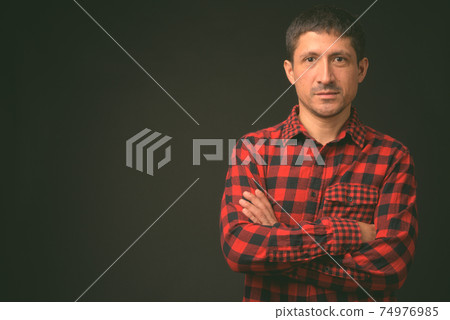 Portrait of Hispanic man against black background 74976985